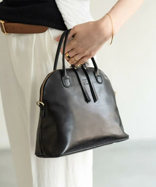 A woman has a bag (color: Black) in her hand