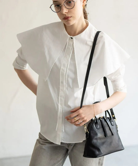 A female model is carrying a shoulder bag "Hone S-size (Version 2)" over her shoulder. Color:Black