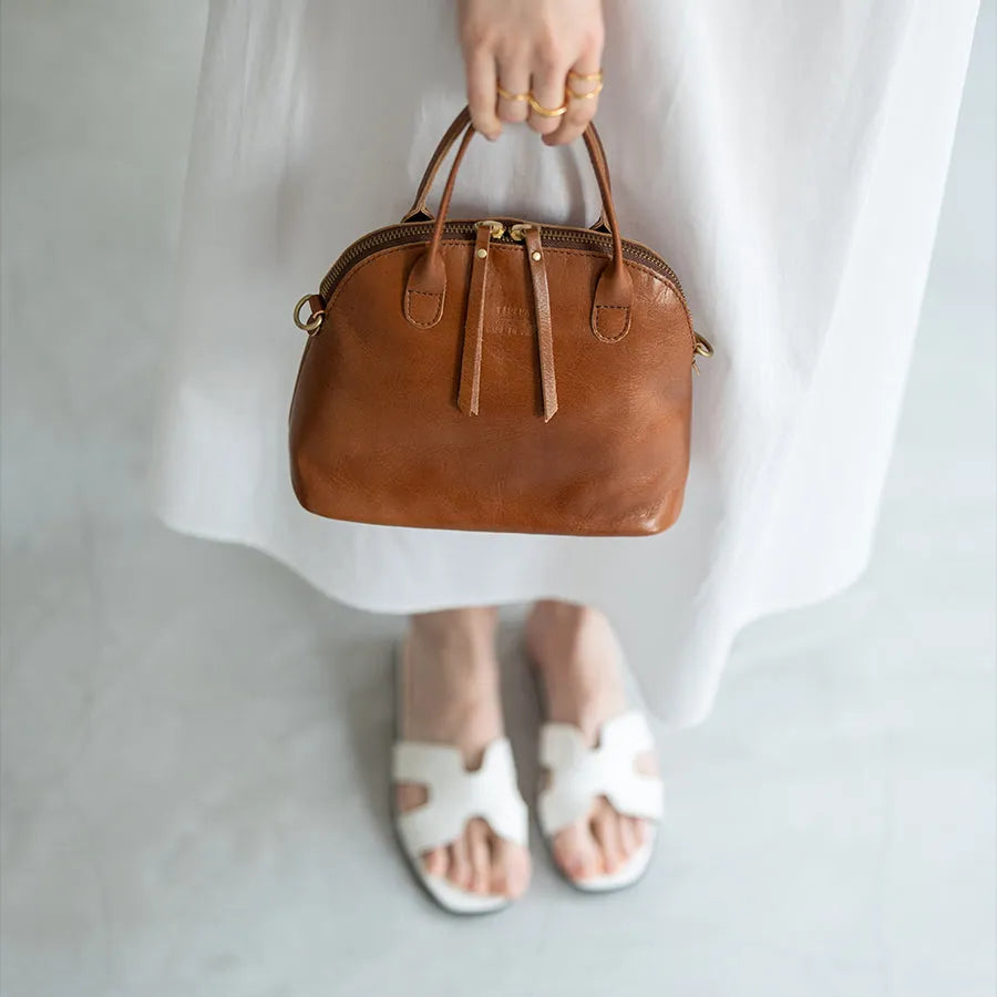 A female model is holding a tote bag "Hone S-size (Version 2)" Color:Camel brown