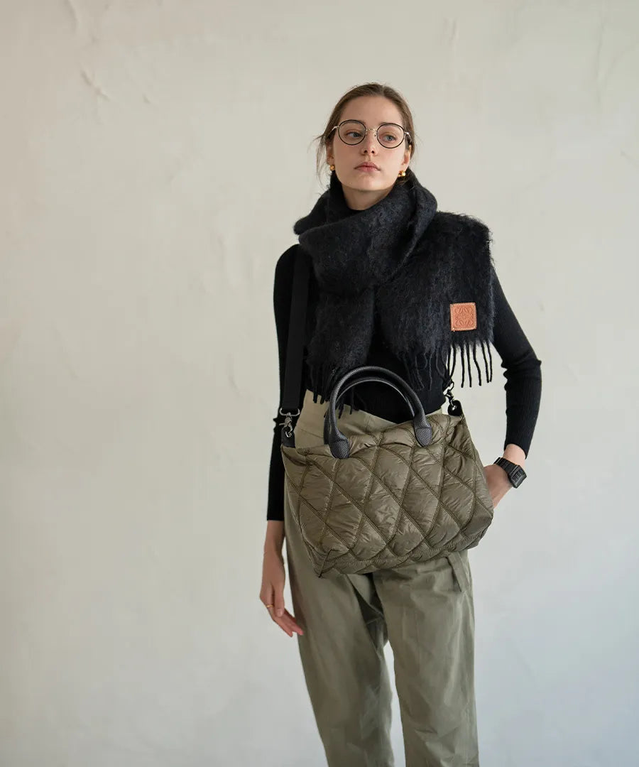 A female model is carrying a shoulder bag "Lanef" over her shoulder.Color:Olive