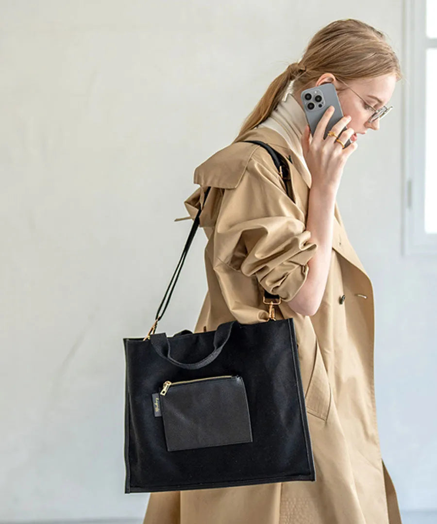 A female model is carrying a shoulder bag “Lesche” over her shoulder. Color:Black