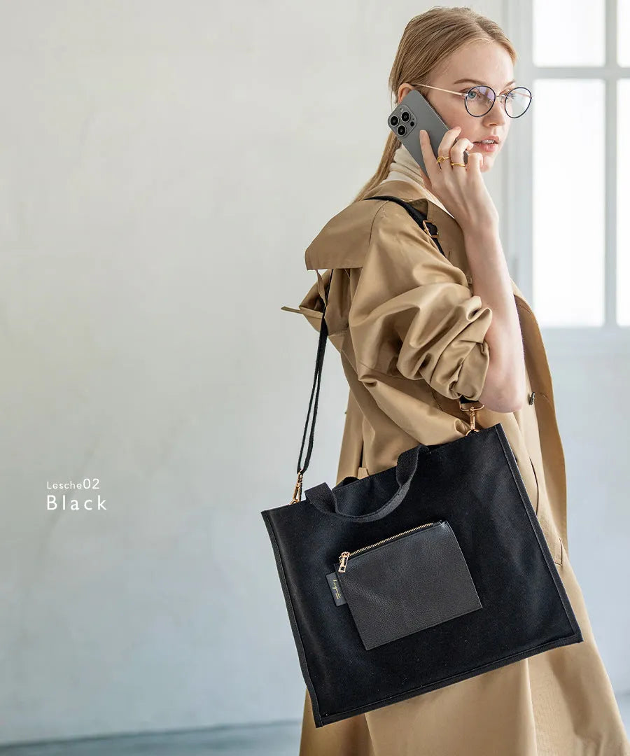 A female model is carrying a shoulder bag “Lesche” over her shoulder. Color: Black