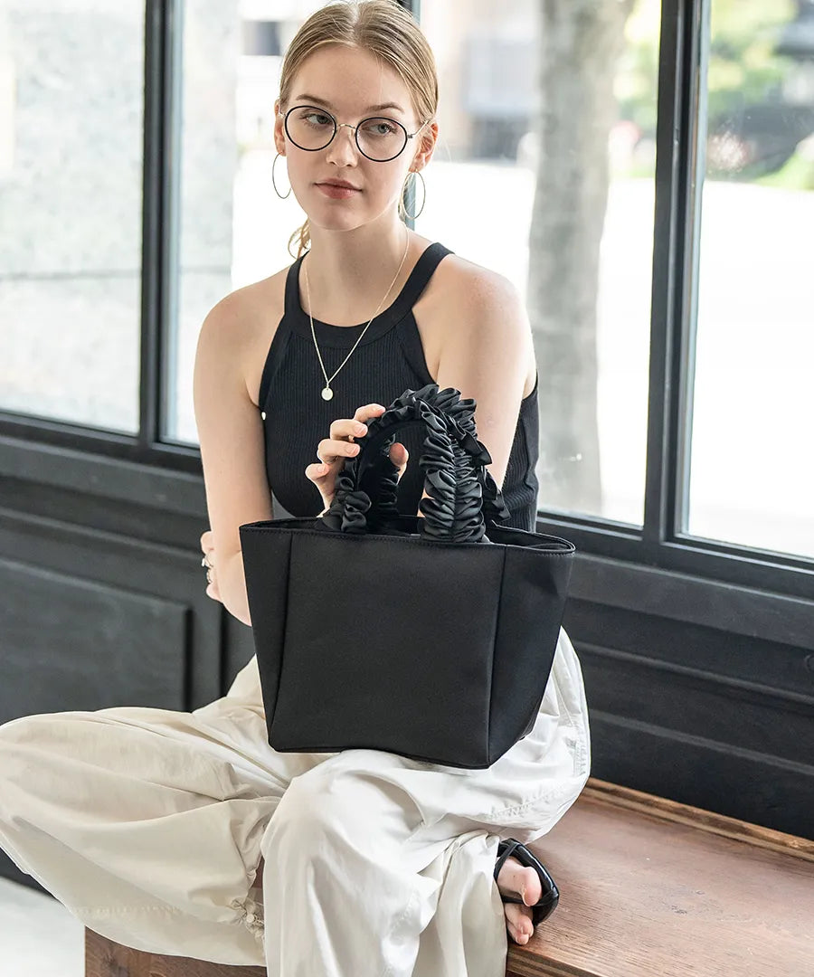 A female model is carrying a tote bag “lifuka nylon S” Color: Black