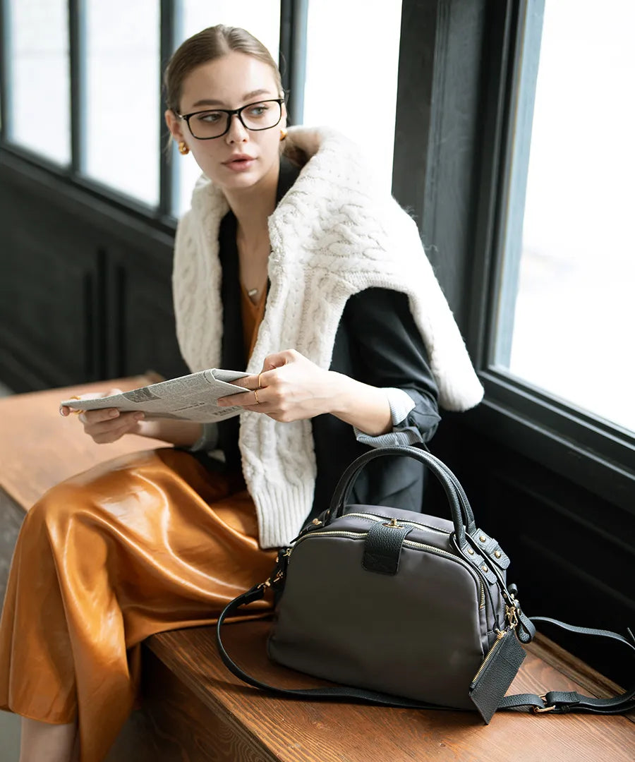 There is a bag "Mini Nylon Loche" next to the woman.Color:Gray black