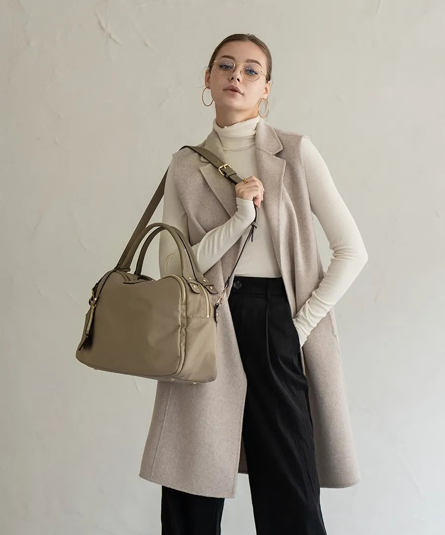 A female model is carrying a shoulder bag "Nylon Loche L" over her shoulder.