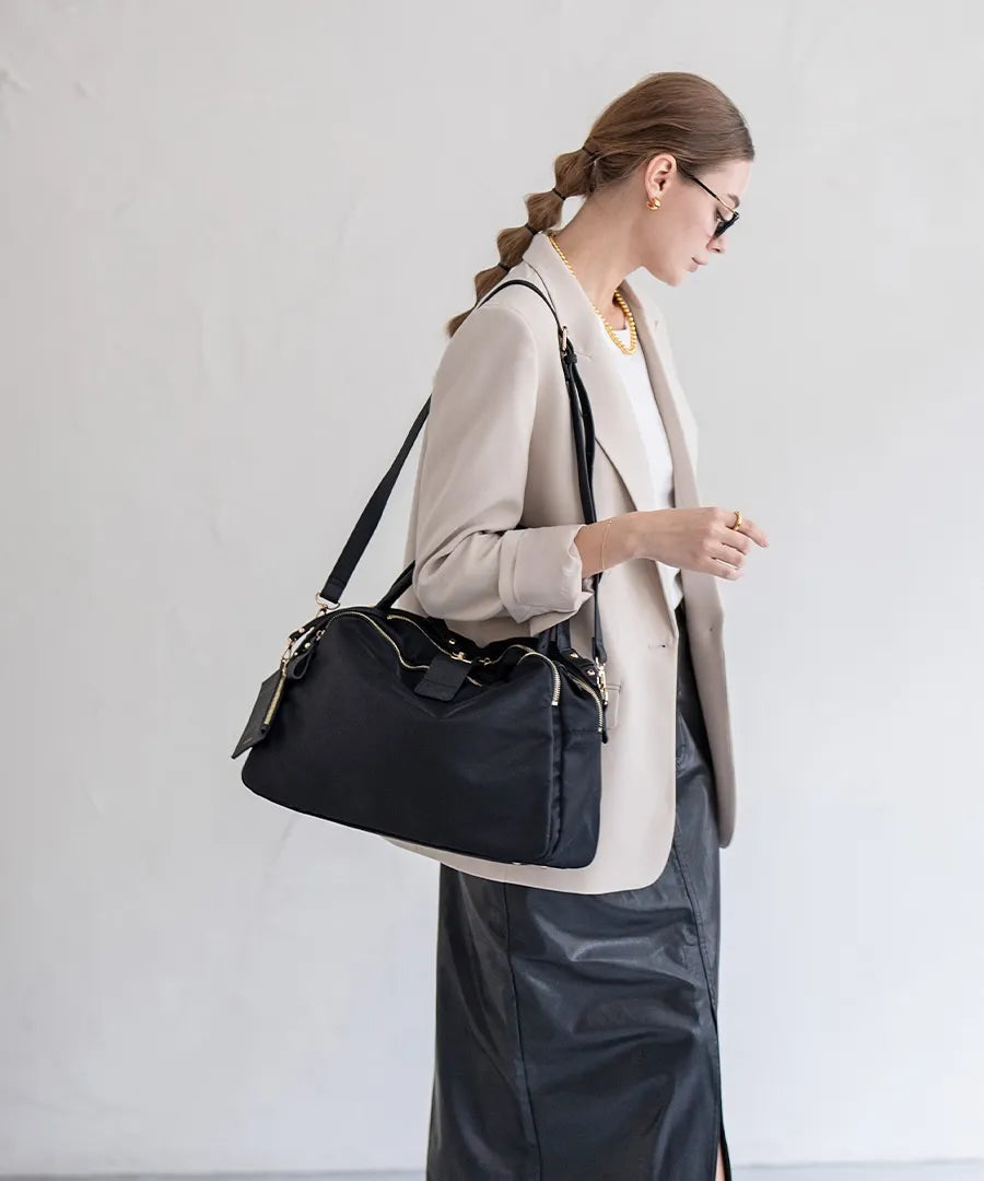 A female model is carrying a shoulder bag "Nylon Loche L" over her shoulder.