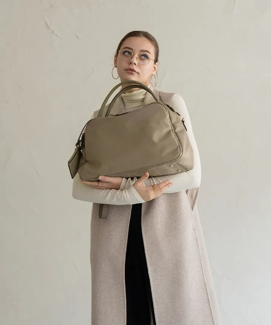 A female model is holding a shoulder bag "Nylon Loche L".