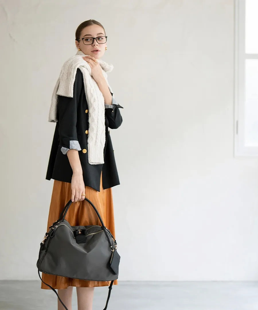 A female model is holding a shoulder bag "Nylon Loche L".