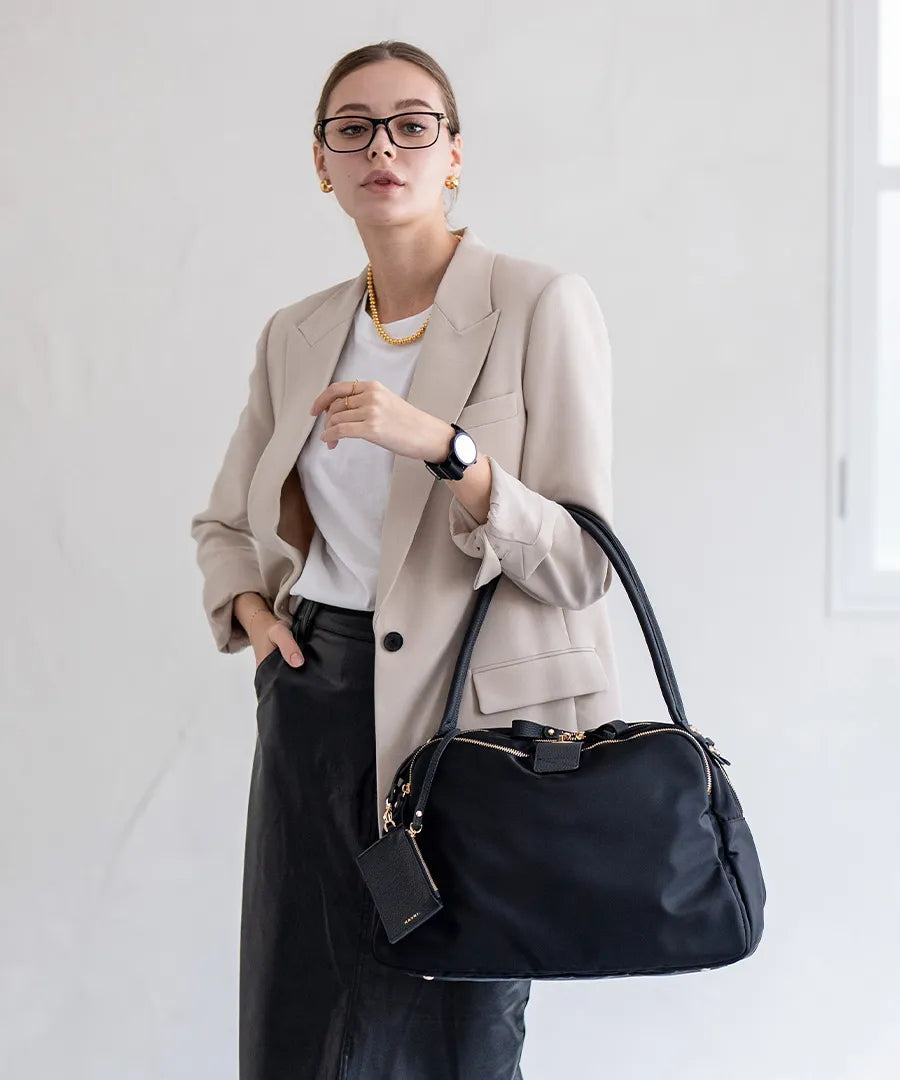 A female model is holding a tote bag "Nylon Loche L (Long Handle)".Color:Black