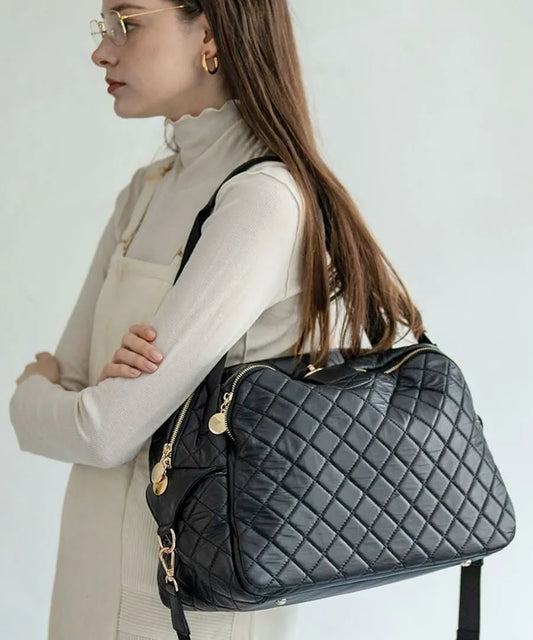 A female model is holding a tote bag "Loche Quilted Boston Bag".