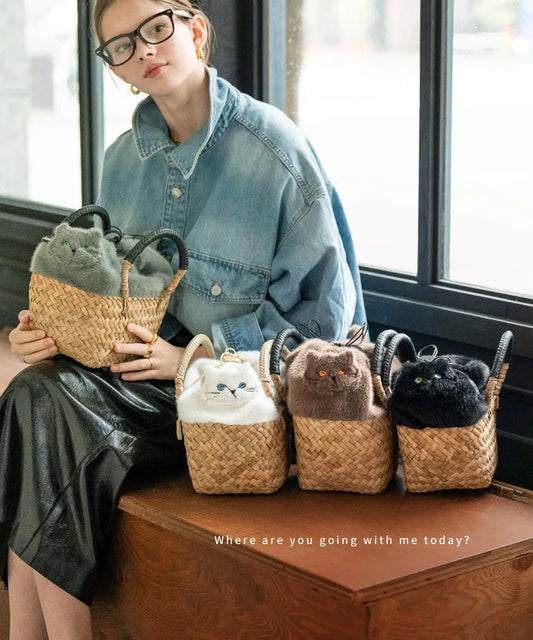 A female model is sitting and holding a cat motif fur basket bag "Minetpluche" Color: Mocha, Milk, Black, Aqua