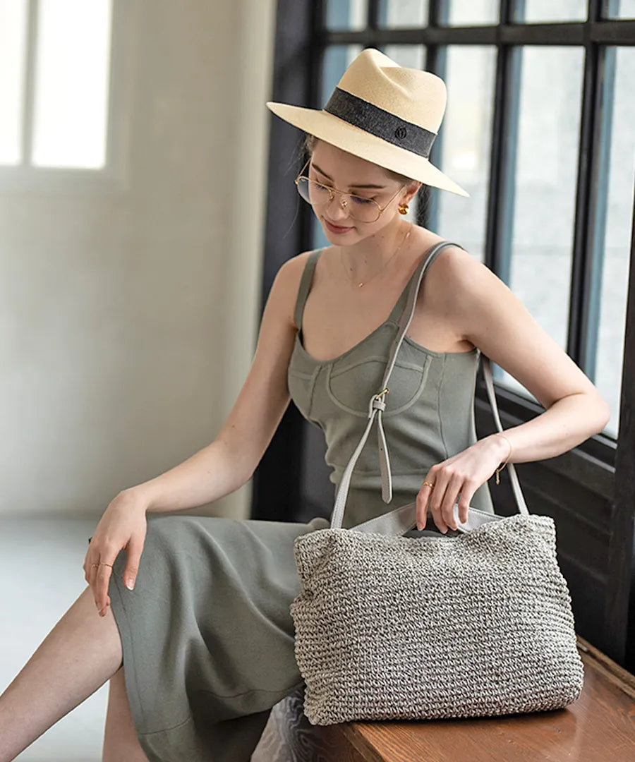 A female model is sitting and holding a tote bag "Najia".