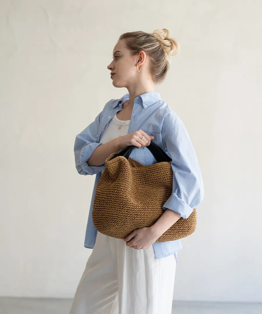 A female model is holding a hand bag "Najia".