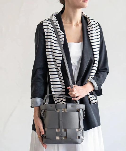 A female model is carrying a shoulder bag "Opmeil" over her shoulder. Color:Gray