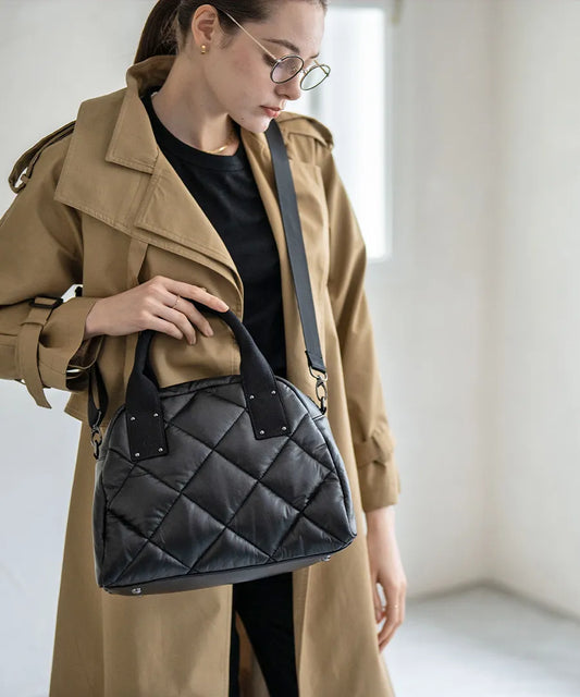 A female model is holding a tote bag "Peremo (Version 2)".Color:Black