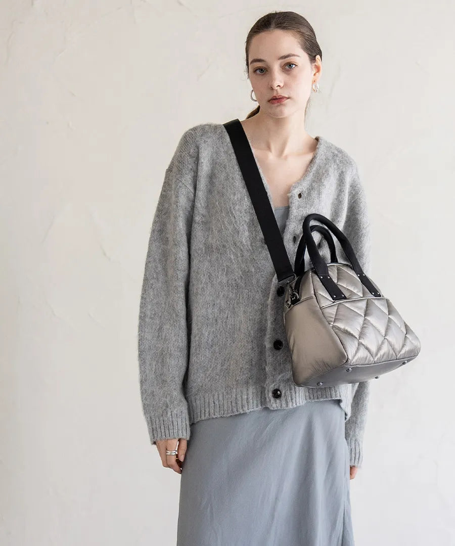 A female model is carrying a shoulder bag "Peremo (Version 2)" over her shoulder.Color:Champagne silver