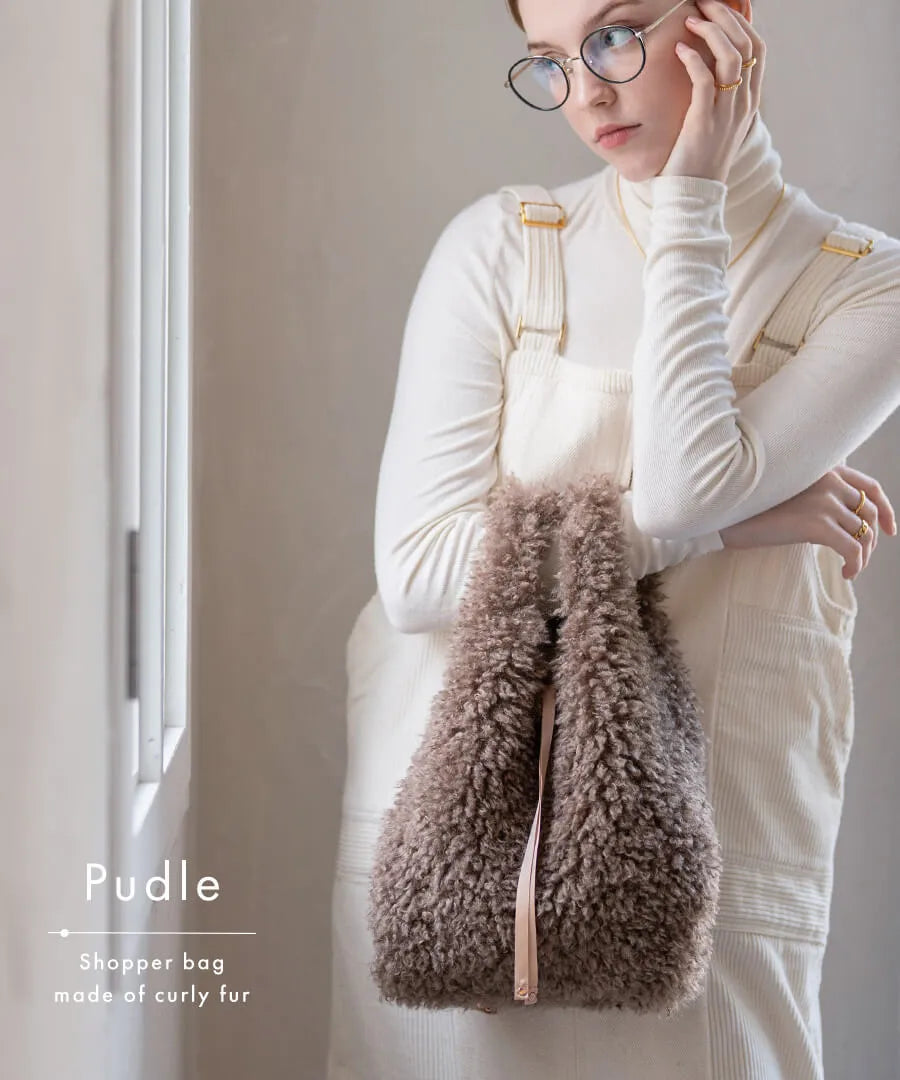 A female model is holding a fur tote bag "Pudle" Color:Mocha brown