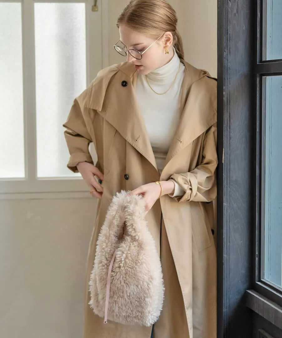 A female model is holding a fur tote bag "Pudle" Color:Ivory