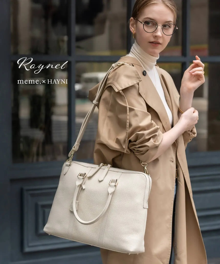 A female model is wearing a bag ”Roynel” over her shoulder. Color: Ivory