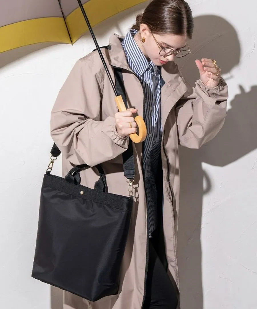 A female model is carrying a shoulder bag "Serem" over her shoulder. Color: Black