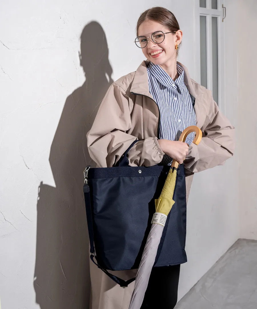 A female model is holding a tote bag "Serem". Color: Navy