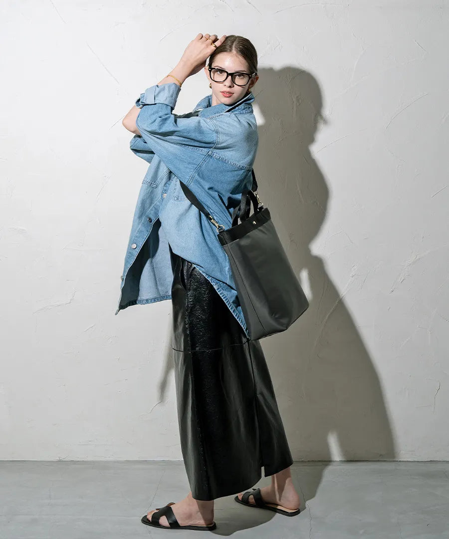 A female model is carrying a shoulder bag "Serem" over her shoulder. Color: Dark gray