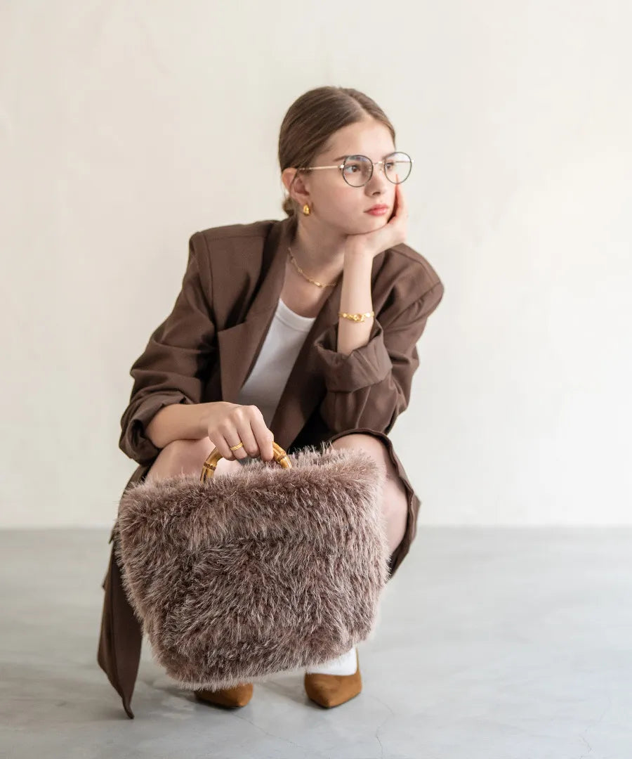 A female model is holding a fur bamboo tote bag "Sufy". Color:Mocha