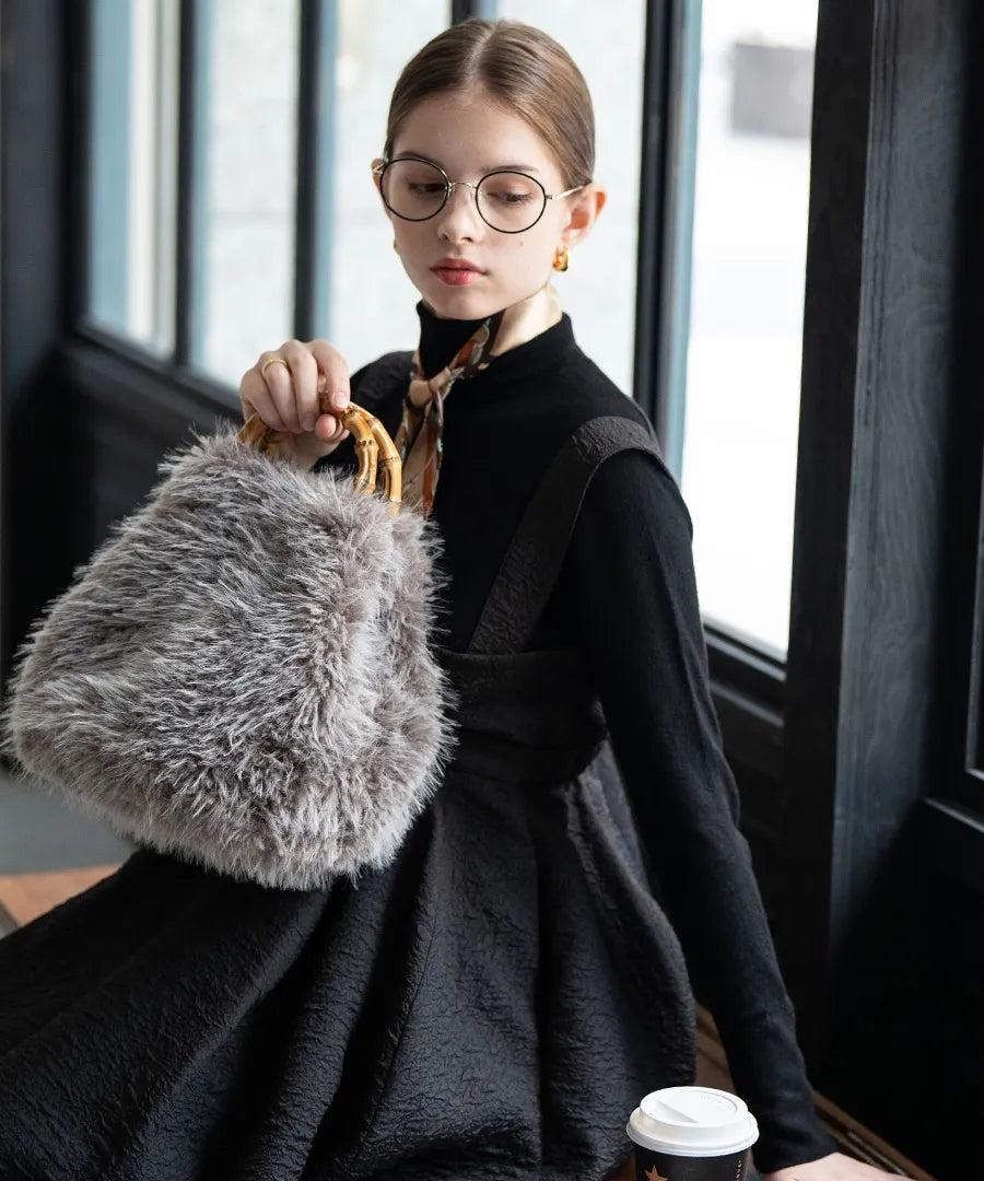 A female model is holding a fur bamboo tote bag "Sufy". Color:Gray